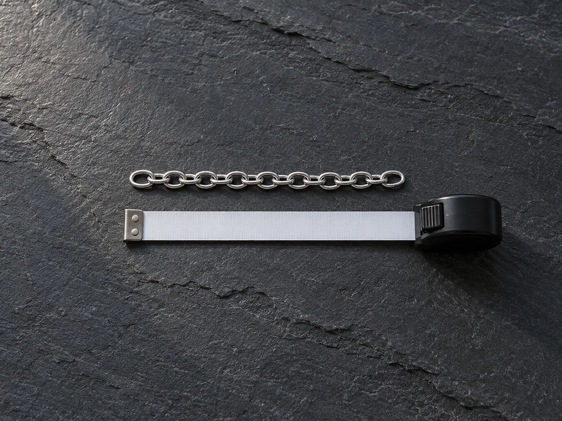 Natural window light illuminates one short unfinished straight chain section alongside an unmarked measuring tape.