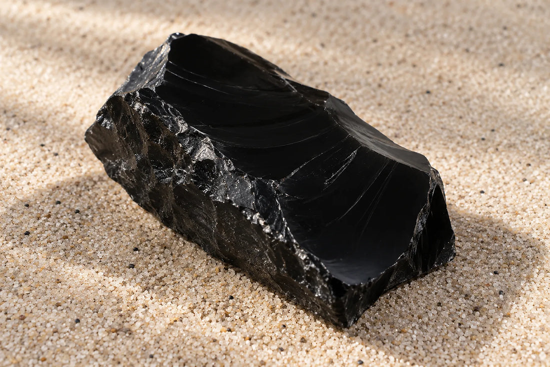 Natural window light illuminates one smooth deep black onyx rough slab with a broken edge.