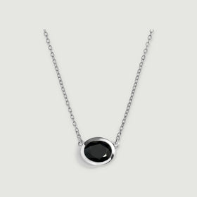An oval black obsidian pendant sits in a polished white-rhodium-plated bezel on a matching chain.