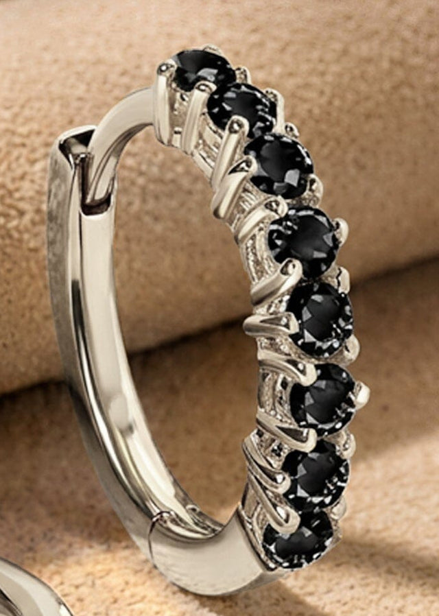 Faceted black stones and polished white rhodium plated prongs fill a close view of the upright earring.