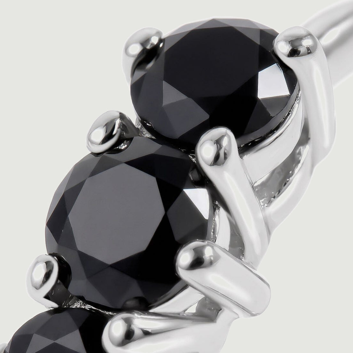 This close view shows black onyx facets and bright white rhodium plated settings.