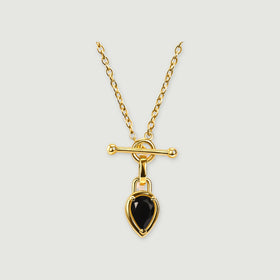 A yellow gold plated necklace has an oval-link chain, a horizontal bar clasp, and a pear-shaped black stone on a light grey background.