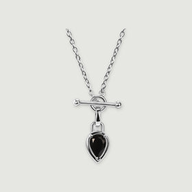 A bright silver-tone necklace shows a round clasp beneath a polished bar and a dangling black pear-shaped pendant.