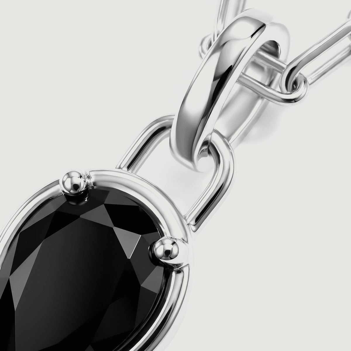 The polished silver-tone bail and rounded prongs frame a close-up of the black gemstone.