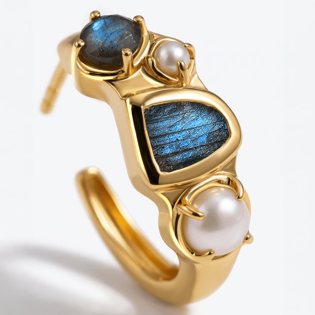A yellow gold plated hoop fills the frame with a blue textured labradorite center and smooth white pearls.