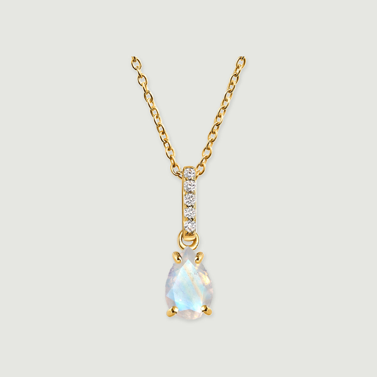 A yellow gold necklace has a pear-shaped moonstone beneath a vertical row of five clear stones on a light gray background.