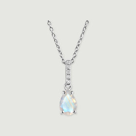 A silver chain supports a pale blue pear-shaped moonstone and a slim stone-set bail against light gray.