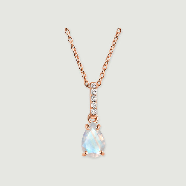 A rose gold chain and four rounded prongs frame an iridescent pear-shaped moonstone on a soft gray surface.