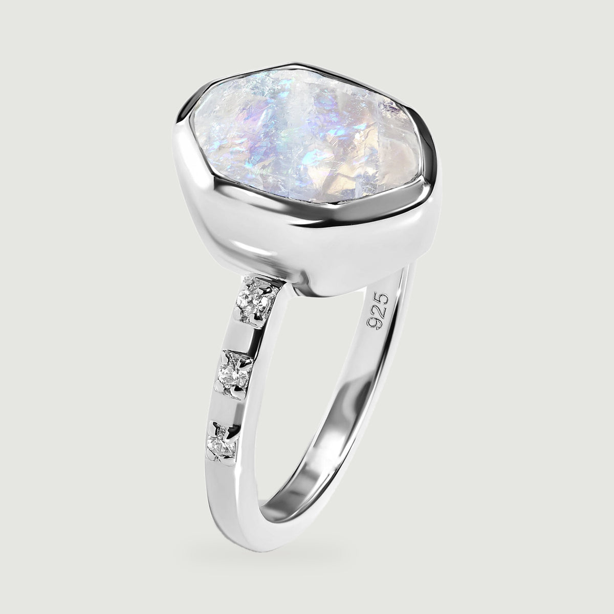 An upright silver ring shows the textured moonstone surface, deep bezel, and narrow stone-set band.