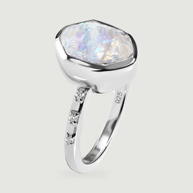 An upright silver ring shows the textured moonstone surface, deep bezel, and narrow stone-set band.