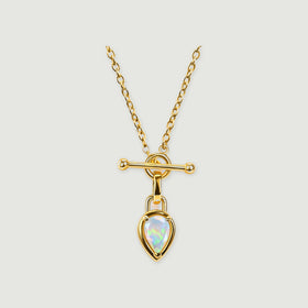A yellow gold necklace with oval chain links, a horizontal bar, and a pear-shaped opal pendant rests on a light gray background.