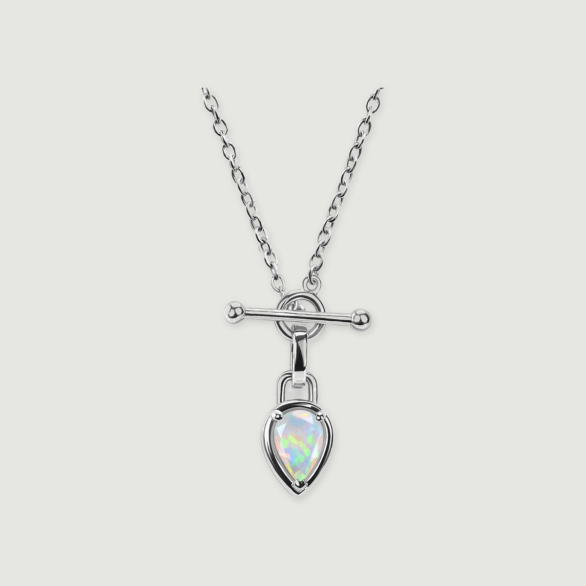 A bright silver-colored necklace with a pear-shaped opal suspended below a circular connector is centered on light gray.