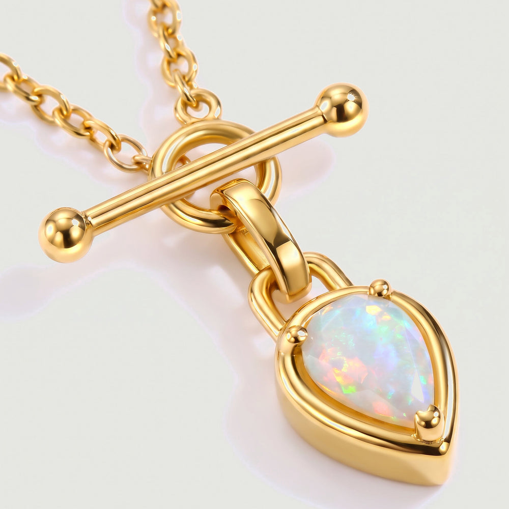 A close view shows the yellow gold bar, rounded connector, and three prongs surrounding a colorful pear-shaped opal.