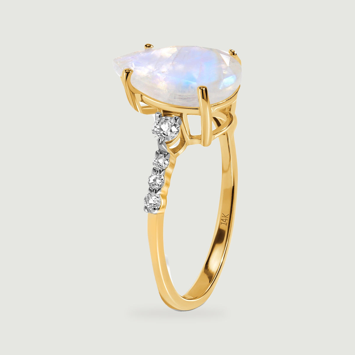 The raised moonstone basket and slim yellow gold band are shown from the side.