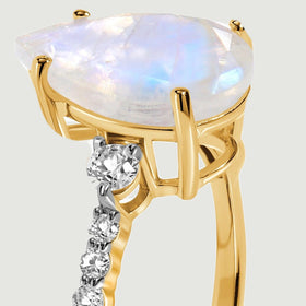 The open yellow gold basket supports the faceted moonstone above the diamond-set shoulder.