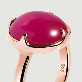 The rounded pink cabochon rises above a smooth rose-gold rim in this close side view.