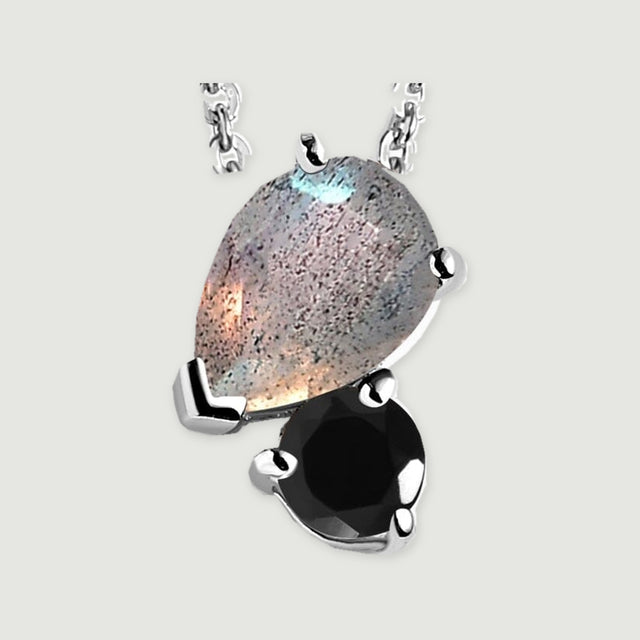 A close view shows silver prongs around a flecked pear-shaped labradorite and a glossy round black obsidian.