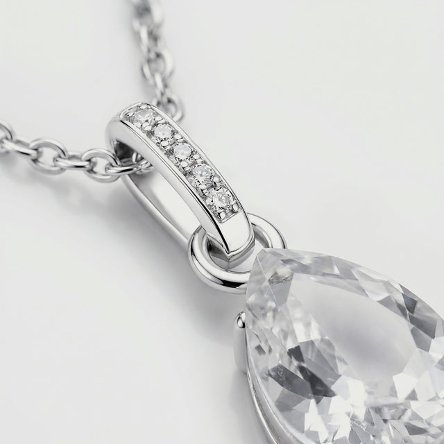 A close view shows five round stones in the silver bail beside the clear pendant and polished connecting ring.