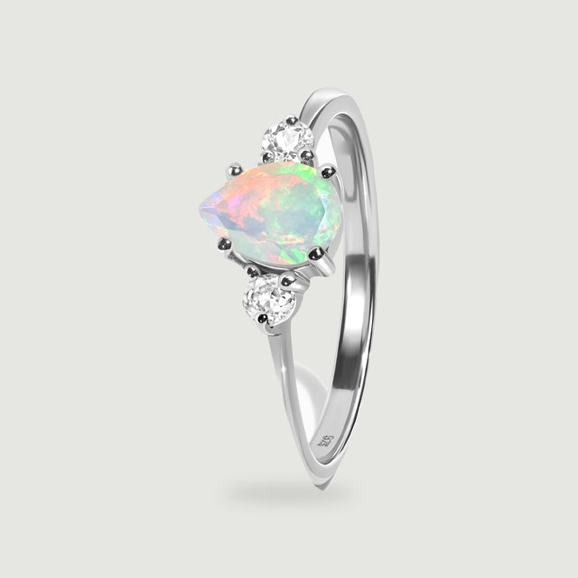 The silver ring stands at an angle with its pear-shaped opal, open band and prongs visible.