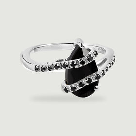 A polished silver ring with a pear-shaped black stone and two curved rows of small black stones rests on light gray.