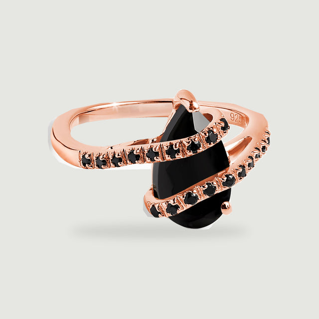 A rose gold ring shows a faceted black pear-shaped stone crossed by two narrow stone-set bands.