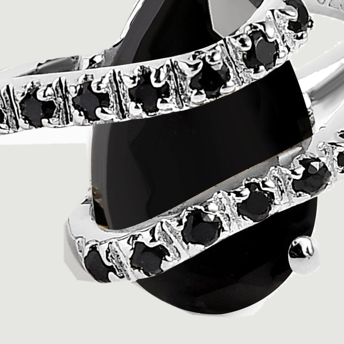 A close view shows the silver prongs and small black stones along the two curved rows across the pear-shaped stone.