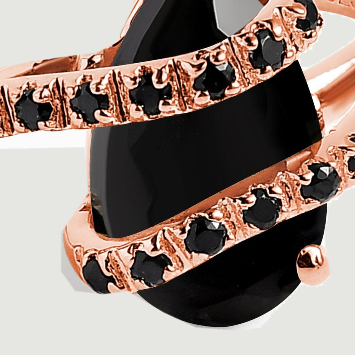 Small round black stones sit in rose gold settings across the dark faceted center stone.