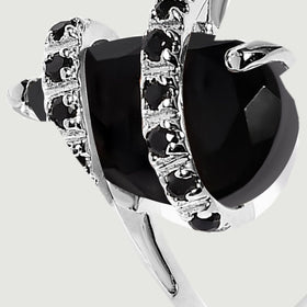 The black stone facets and silver side prongs are shown closely beside a curved row of round black stones.