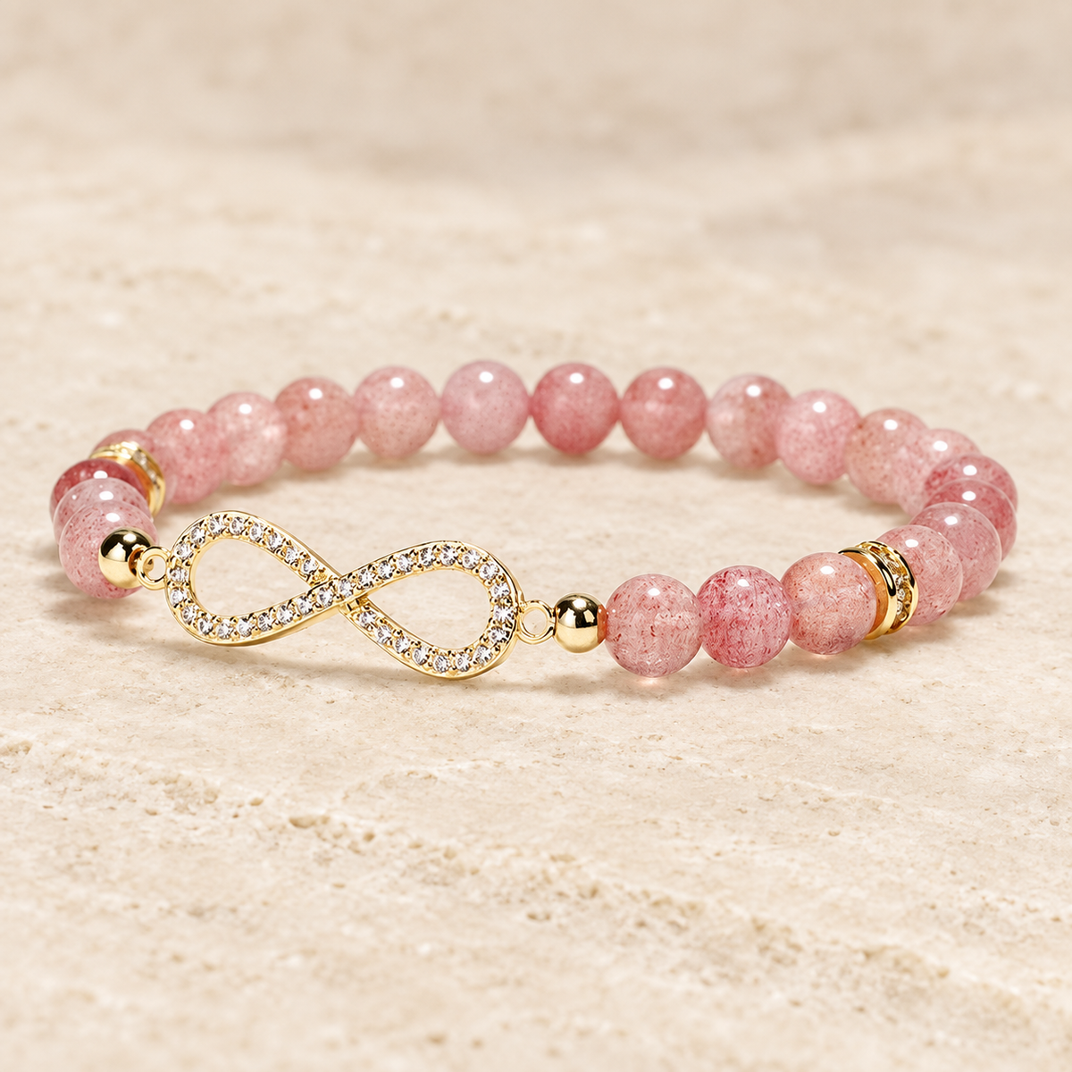 Pink bead bracelet with an infinity centerpiece shown from a low angled view.