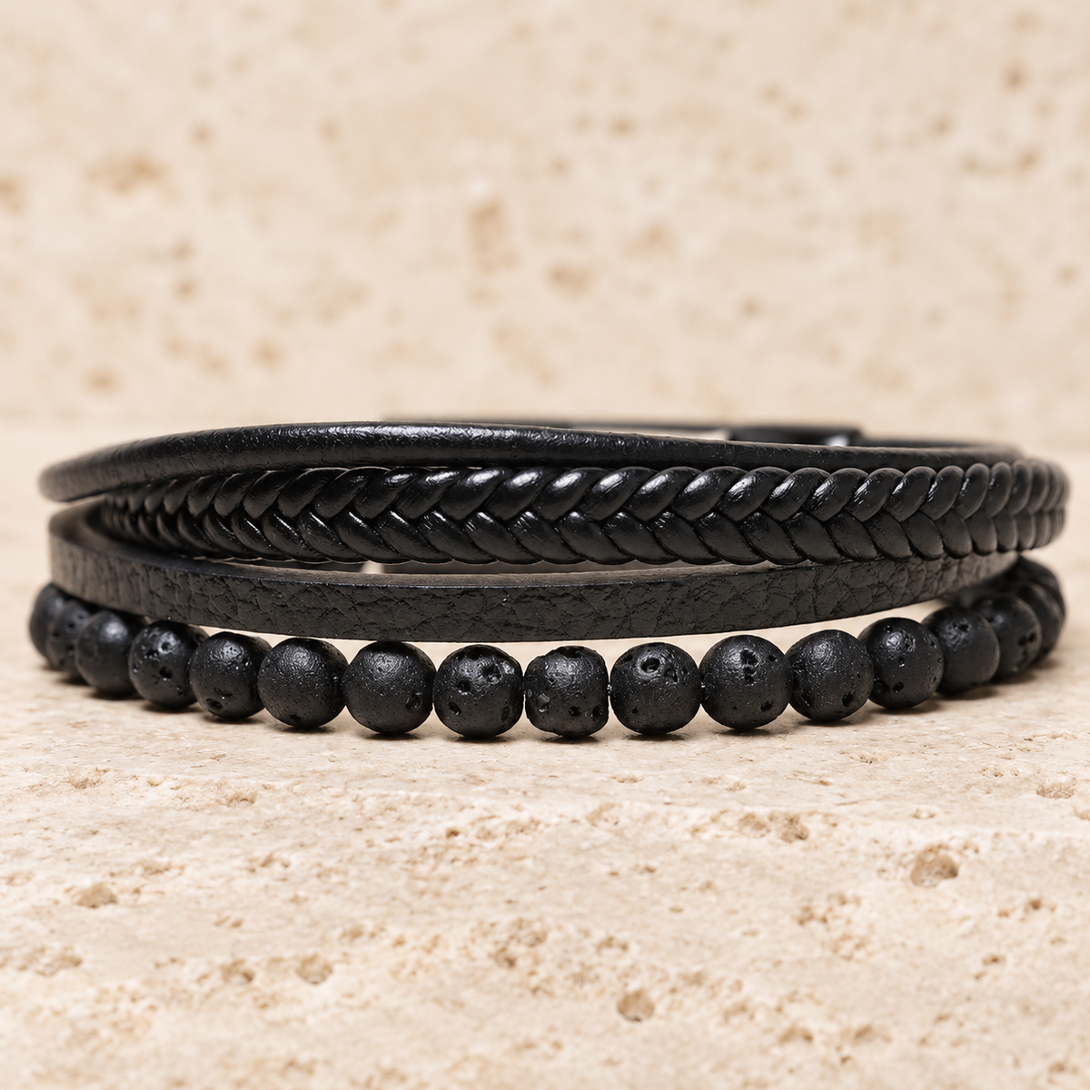 Side view of the Dark Texture bracelet with porous lava beads and braided black bands.