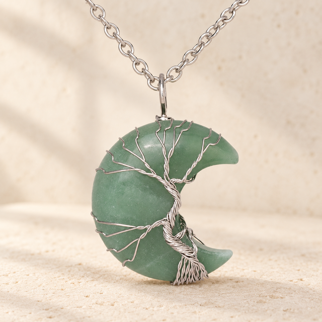 Green crescent pendant wrapped with a silver-toned wire tree.