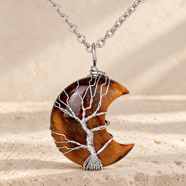 Brown and gold-toned crescent pendant wrapped in a silver-toned wire tree.