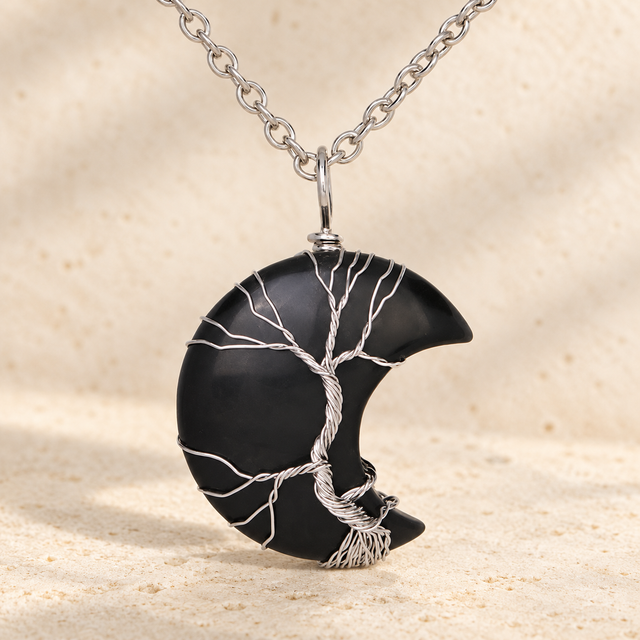 Black crescent pendant with a silver-toned wire tree and chain.