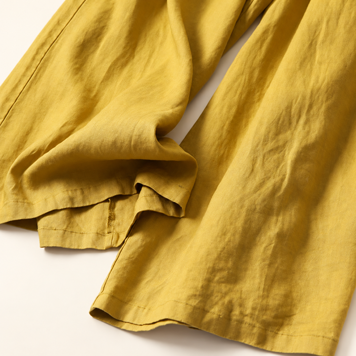 Ease pants in Yellow, draped wide-leg hems and stitching.