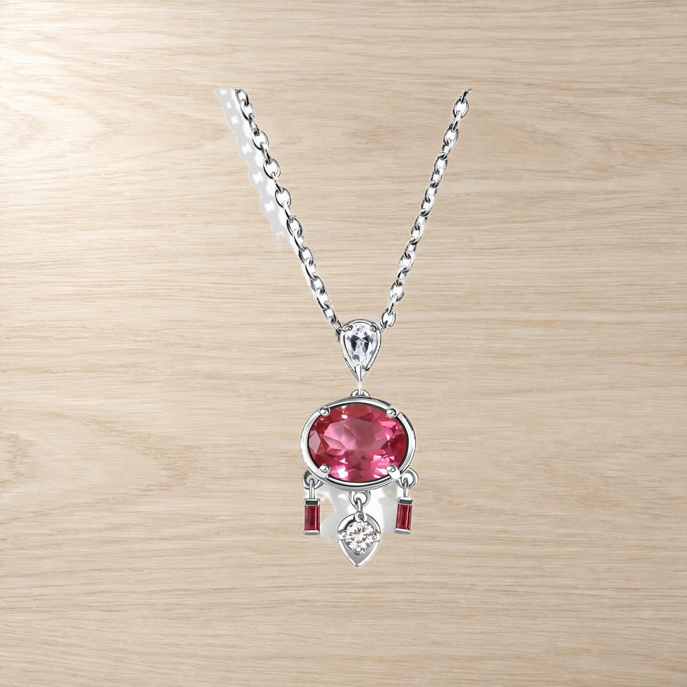 Pink topaz pendant with white zircon accents on a warm wooden table