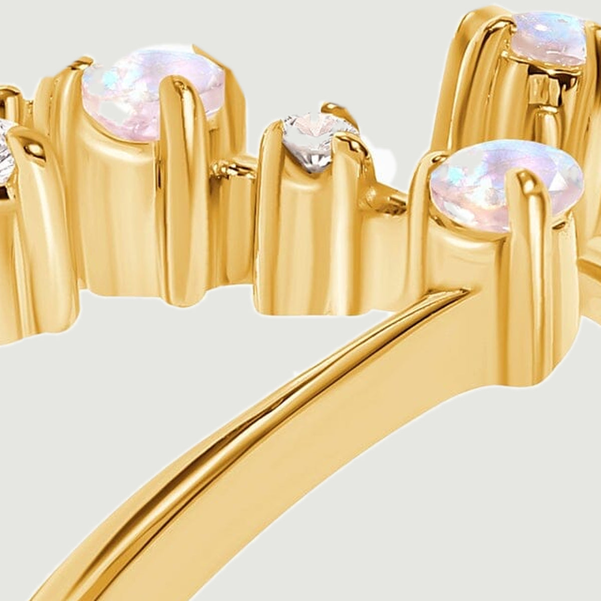 The ring settings appear in profile with rounded stones held above the yellow gold band.