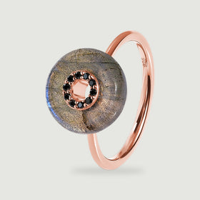 A rose gold vermeil band supports a circular labradorite disc with dark stones around the open centre.