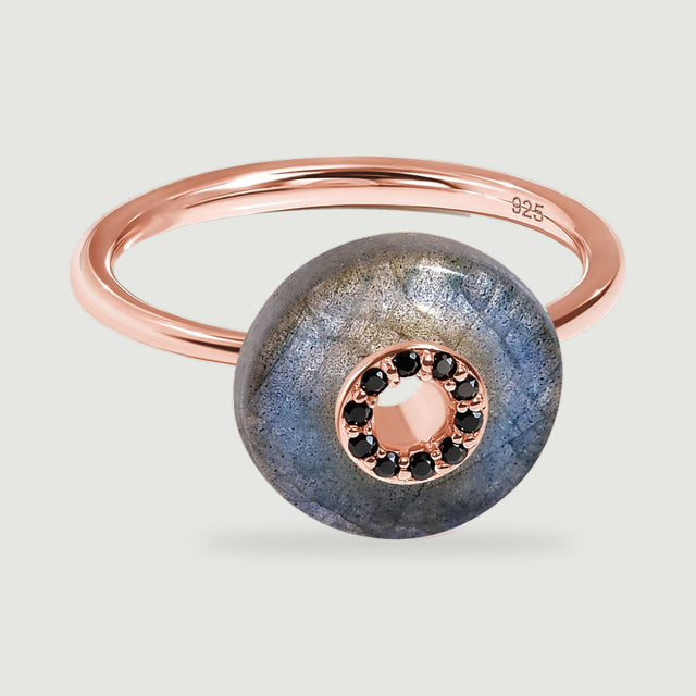 An angled rose gold vermeil ring shows a rounded labradorite disc in front of its smooth oval band.