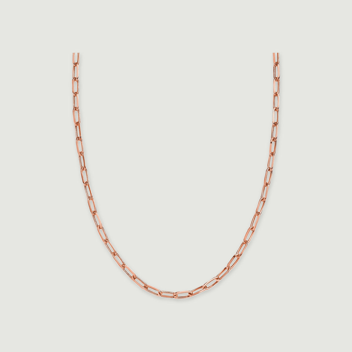 A rose gold tone chain forms a broad curve against a light grey background.