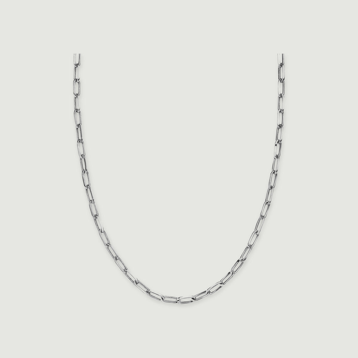 A silver tone necklace shows elongated open links on a light grey background.