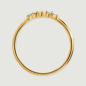 The side of a yellow gold ring reveals its circular band and the raised diamond settings.
