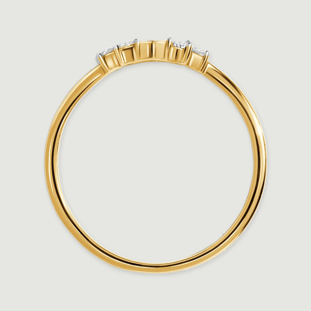 The side of a yellow gold ring reveals its circular band and the raised diamond settings.