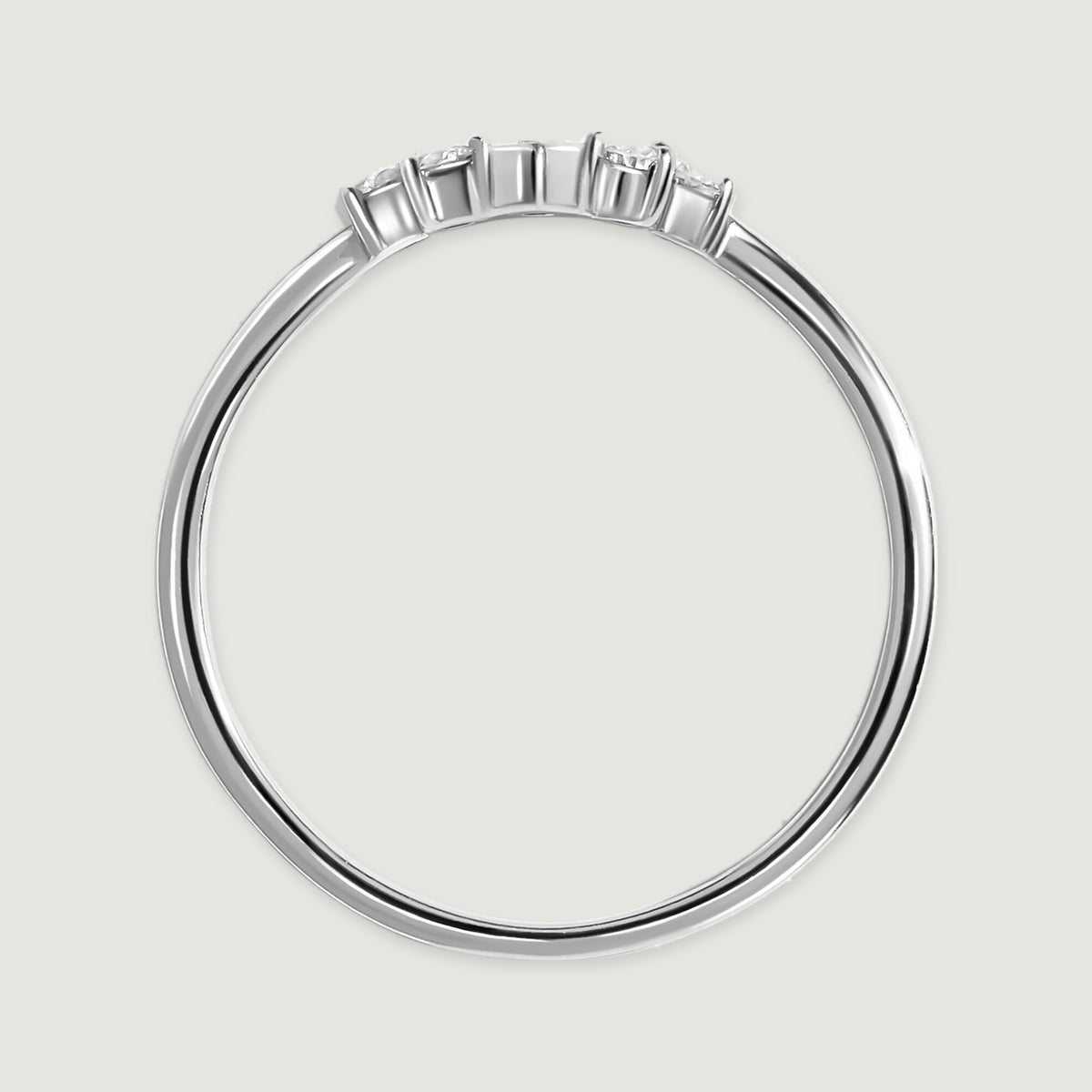 The white gold ring is viewed from the side, showing slender prongs above its polished band.