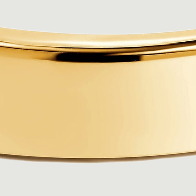The front face of the yellow gold band shows broad reflections and a smooth lower edge.