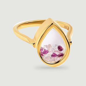 A yellow gold vermeil ring shows its complete curved band and transparent teardrop chamber filled with pink and raspberry stones.