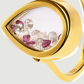 Pink and raspberry stones gather along the curved edge of a yellow gold vermeil teardrop chamber in an angled close-up.