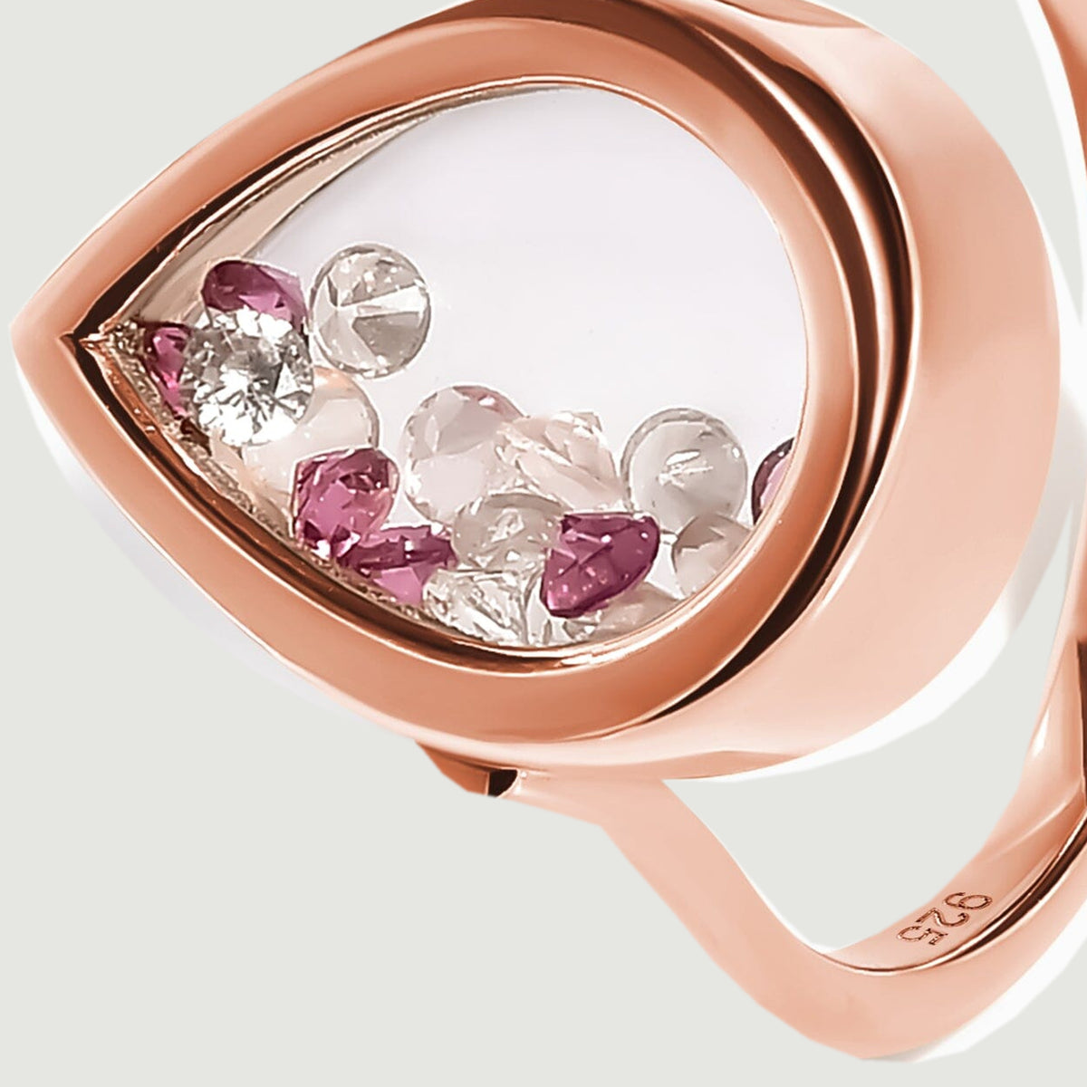 The rose gold vermeil bezel and its rounded side wall surround a clear chamber containing small pink and raspberry stones.