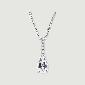 A sterling silver necklace with a clear pear-shaped pendant and a stone-set bail rests on a light gray background.
