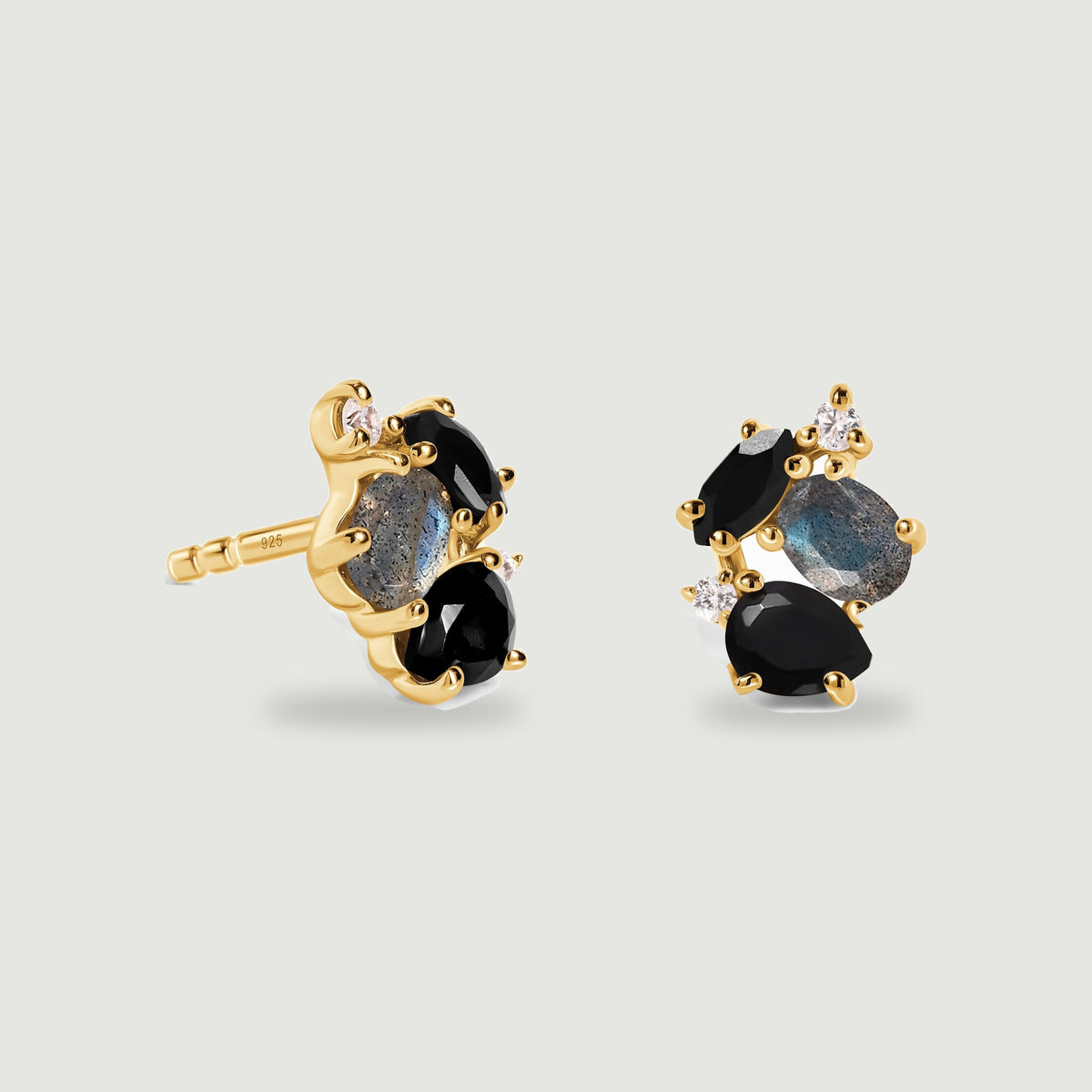 Yellow gold vermeil earrings reveal polished prongs, dark stones and oval labradorite above soft contact shadows.