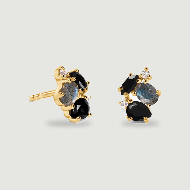 Yellow gold vermeil earrings reveal polished prongs, dark stones and oval labradorite above soft contact shadows.
